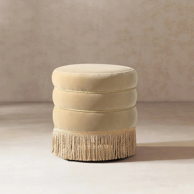 Pouf rond tapissé avec franges en fil doré